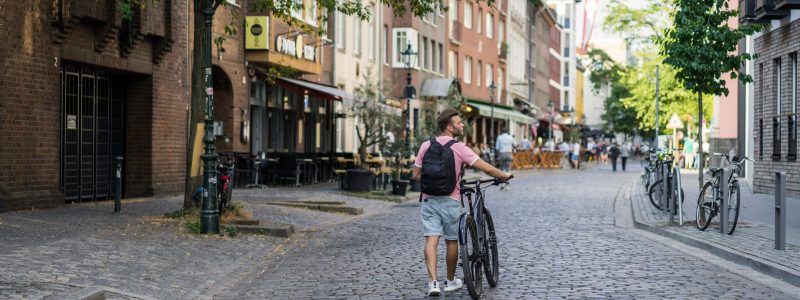 Young sports man on a bicycle in a European city. Sports in urban environments.